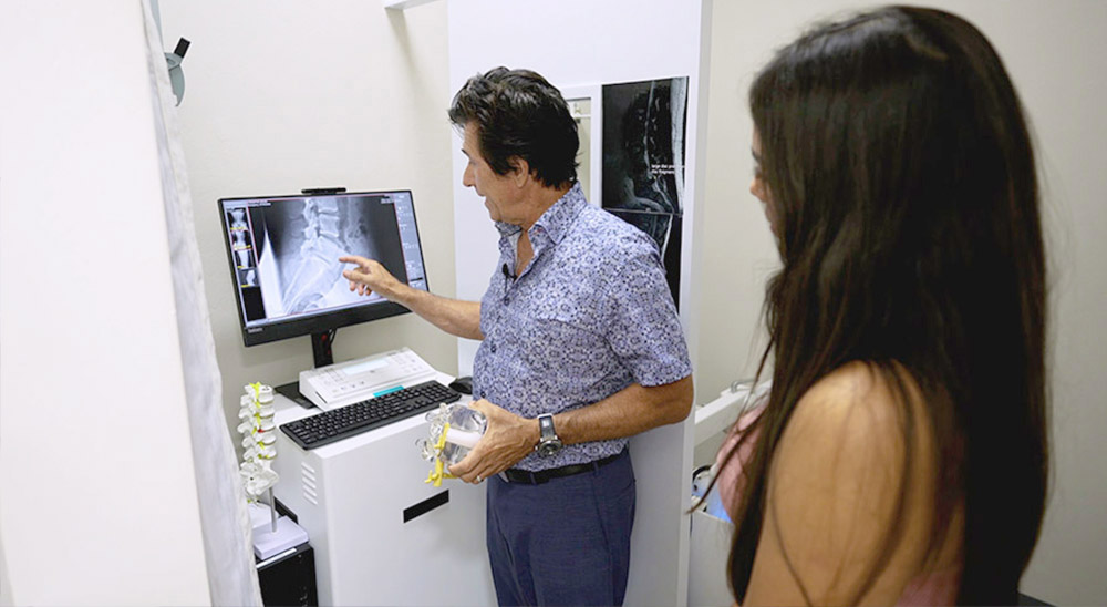 Dr. Ivan Bracic reviewing a digital X-ray with a patient at Novaré Injury Care