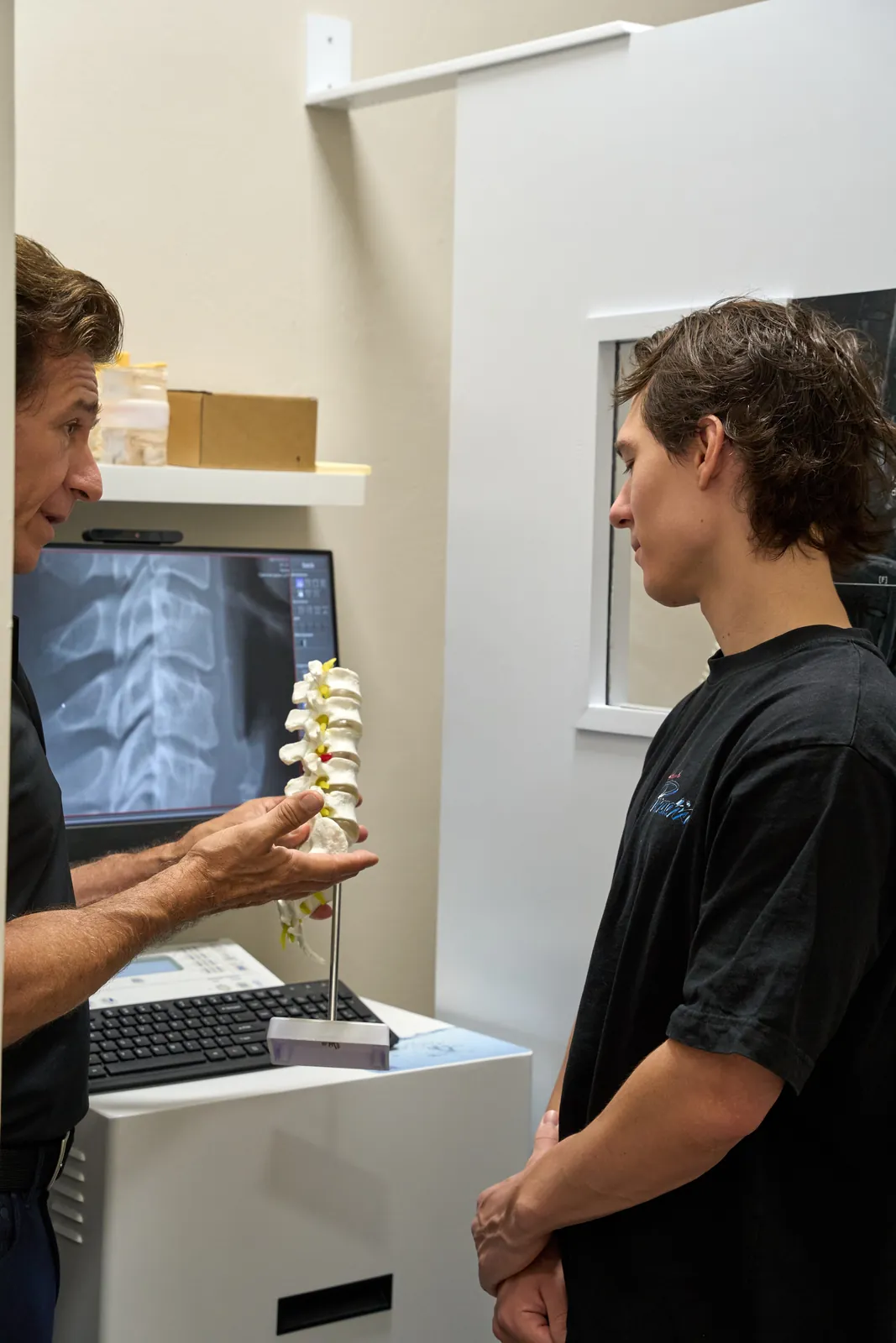 Medical provider consulting with a patient on spinal imaging at Novaré Injury Care