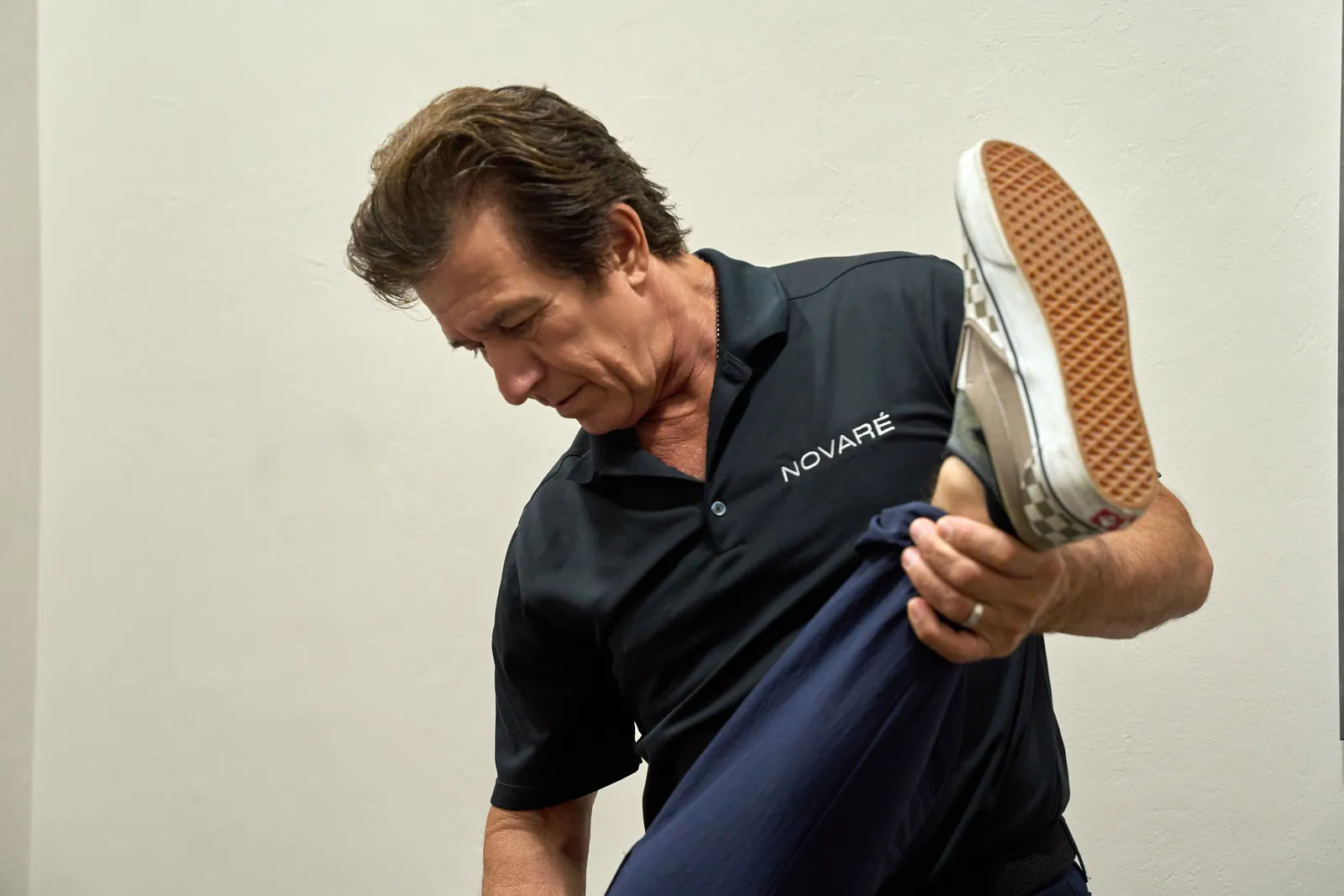 Practitioner performing lower leg assessment for sciatica evaluation at Novaré